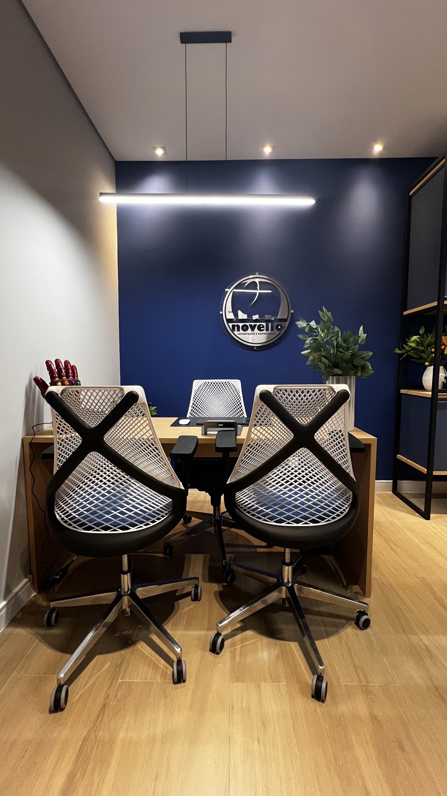 Sala de diretoria com parede azul no escritório Novello Importação e Exportação, projeto corporativo Studio Mies